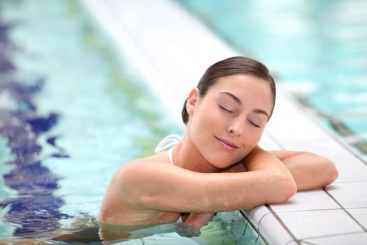 Beautiful young woman relaxing in seawater pool