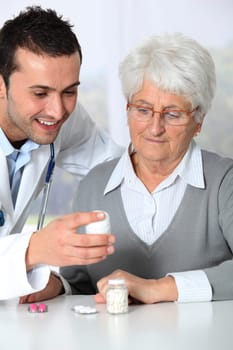 Doctor explaining drugs prescription to elderly woman