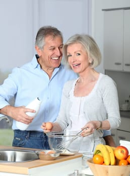 Senior couple in kitchen baking cake