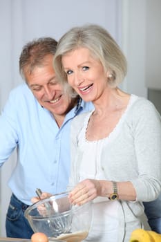 Senior couple in kitchen baking cake