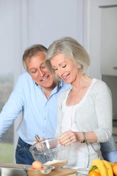 Senior couple in kitchen baking cake