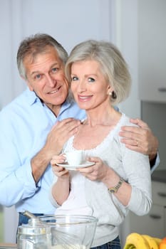 Senior couple taking coffee in kitchen