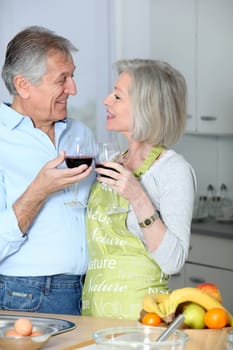 Senior couple drinking wine in kitchen