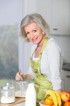 Closeup of smiling senior woman baking in kitchen