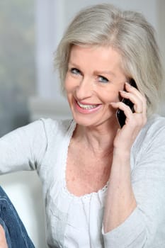 Happy senior woman talking on mobile phone