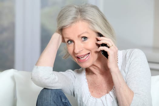 Happy senior woman talking on mobile phone