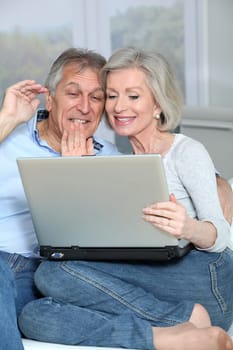 Senior couple waving at web camera