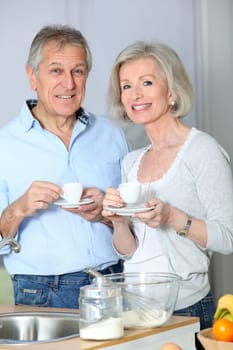 Senior couple taking coffee in kitchen