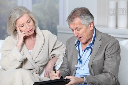 Doctor writing prescription to patient