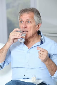 Senior man taking medicine
