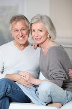 Portrait of happy senior couple sitting in sofa