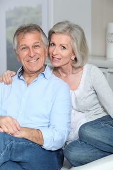 Portrait of happy senior couple sitting in sofa