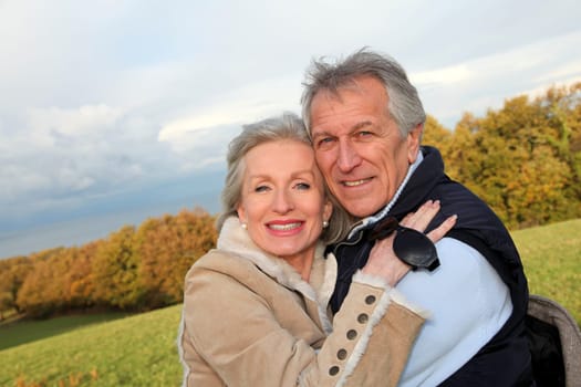 Happy senior couple embracing each other in countryside