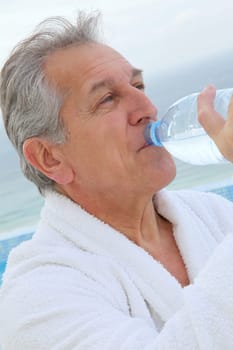 Senior man dinking water from bottle