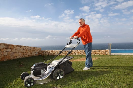 Senior man mowing the lawn