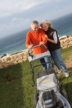 Senior couple mowing the lawn