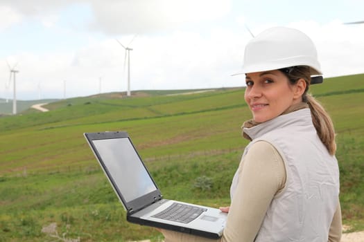 Engineer working on laptop computer in wind turbines field