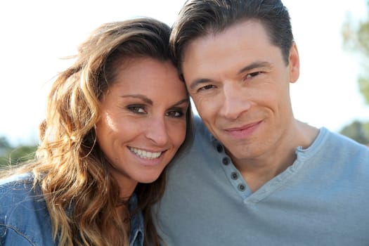 happy couple standing outside on a sunny day