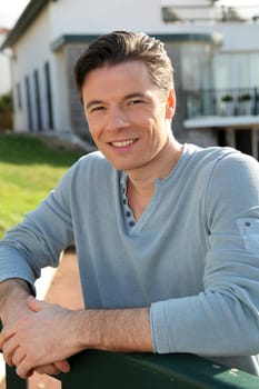 Portrait of smiling handsome man standing in courtyard