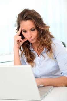 Office worker with desperate look in front of laptop