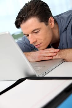 Office worker with exhausted look in front of computer