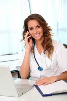 Beautiful nurse talking on mobile phone