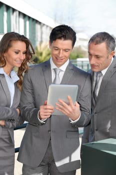 Business people meeting outside with electronic tablet