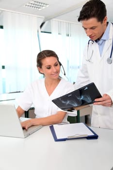 Doctor showing xray results to medical secretary