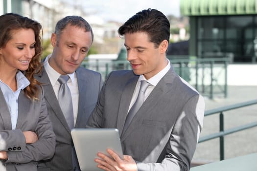 Business people meeting outside with electronic tablet