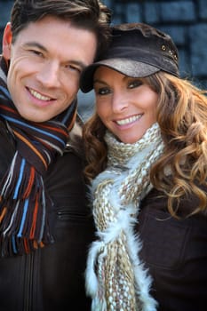 Portrait of happy couple wearing scarves in winter time