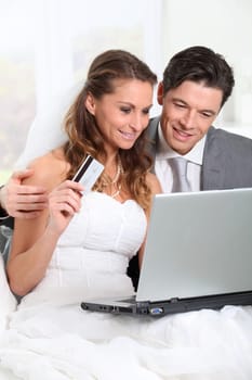 Bride and groom doing shopping on inernet at home