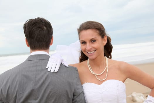 Smiling bride standing on a sandy beach