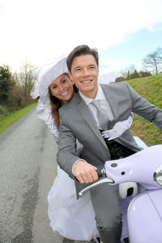 Married couple riding motorcycle on their wedding day
