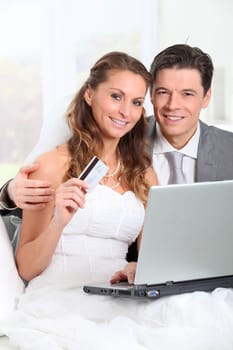 Bride and groom doing shopping on inernet at home