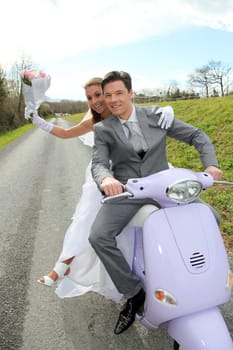 Married couple riding motorcycle on their wedding day