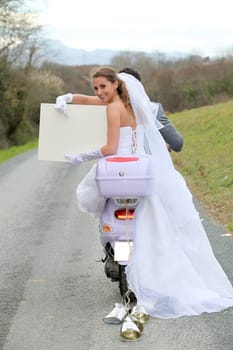Bride on a motorcycle ride holding whiteboard