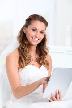 Beautiful bride websurfing on electronic tablet