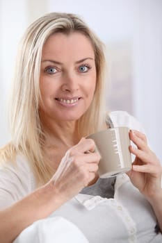 Portrait of beautiful blond woman drinking tea
