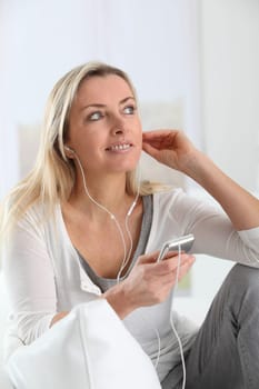 Beautiful blond woman listening to music