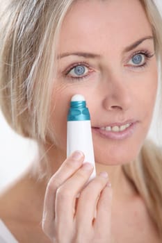 Blond woman applying anti-aging serum on her skin