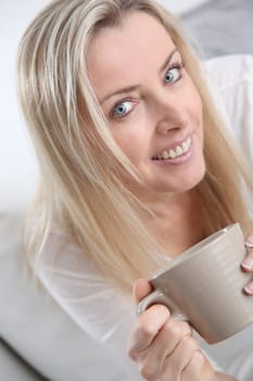 Portrait of beautiful blond woman drinking tea