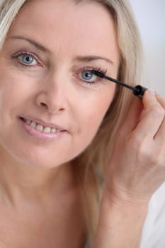 Closeup of woman applying mascara on eyelashes
