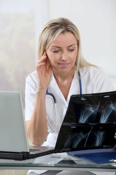 Beautiful blond nurse looking at X-ray