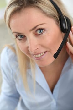 Closeup on blond woman with headset on