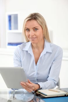 Portrait of office worker using electronic tablet in office