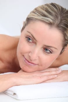 Beautiful adult blond woman on massage bed