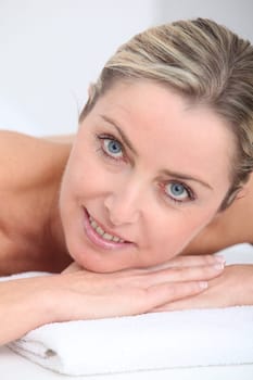 Beautiful adult blond woman on massage bed