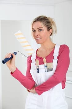 Beautiful blond woman with paint roller