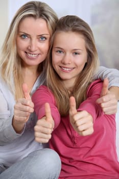 Portrait of mother and daughter with thumbs up