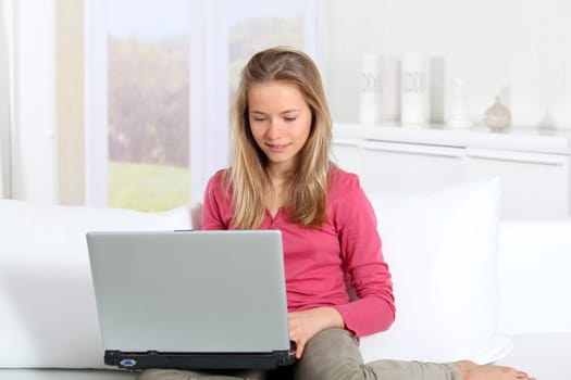 Blond teenager connected on internet at home